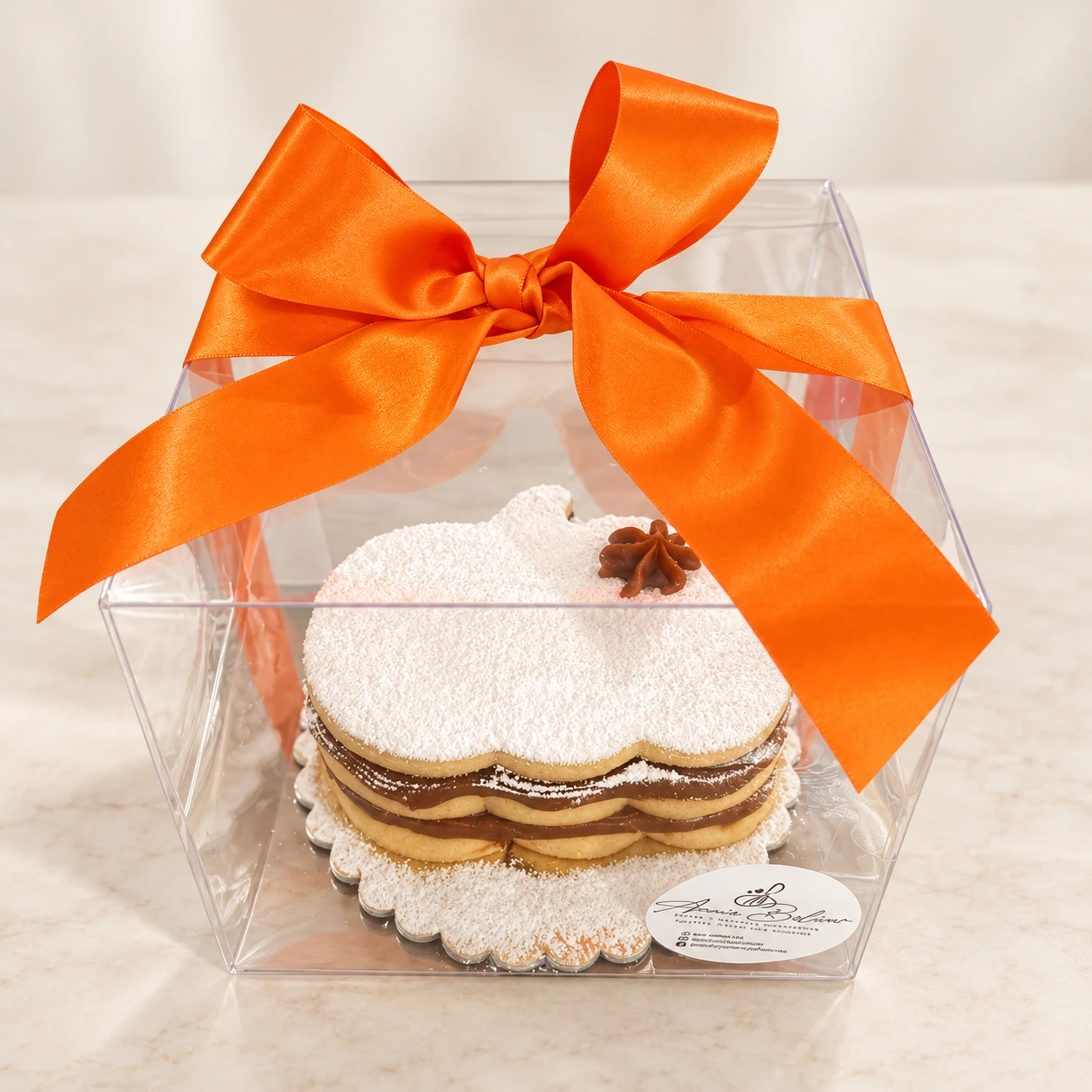Mini cake de alfajor en forma de calabaza, en caja transparente con lazo naranja